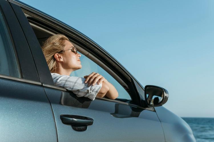 mid-shot-woman-car-looking-sea_23-2148756485.jpg