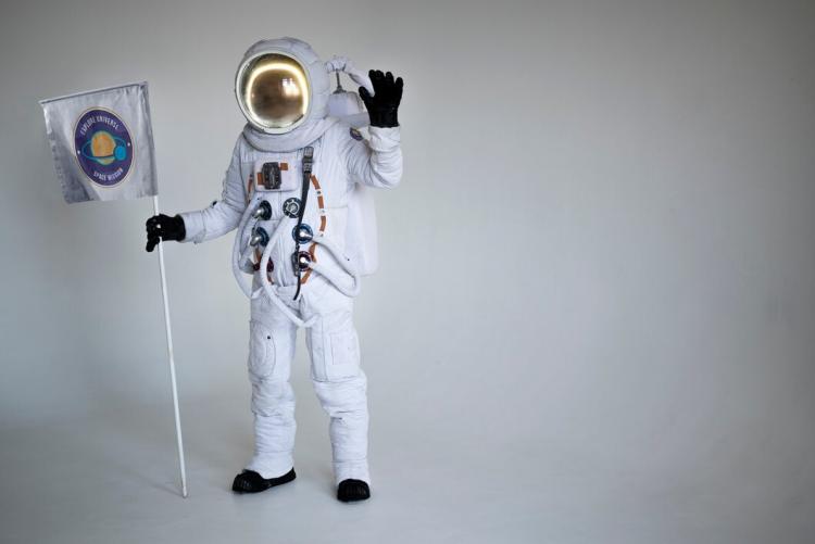 fully-equipped-male-astronaut-holding-flag-waving_23-2149240668.jpg