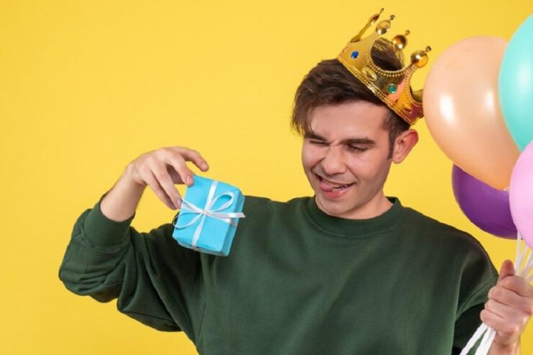 front-view-handsome-young-man-with-crown-holding-balloons-gift-yellow_179666-10324.jpg