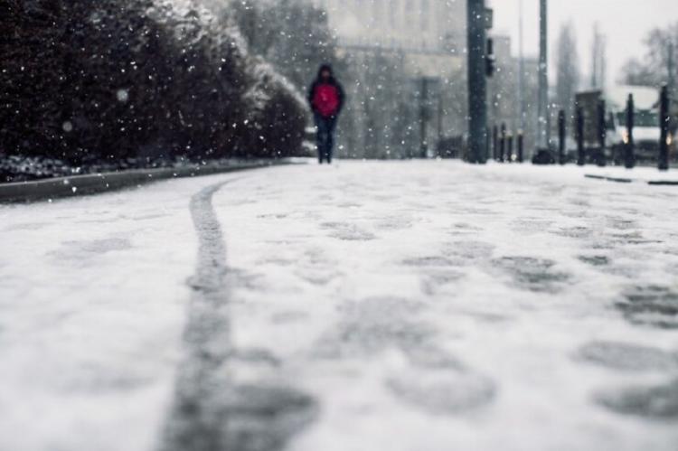 low-angle-shot-person-walking-snow-covered-sidewalk-snow_181624-21806.jpg