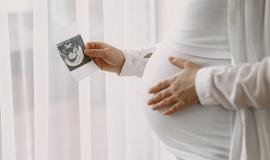 pregnant-woman-standing-by-window-looking-photo_1157-46771.jpg