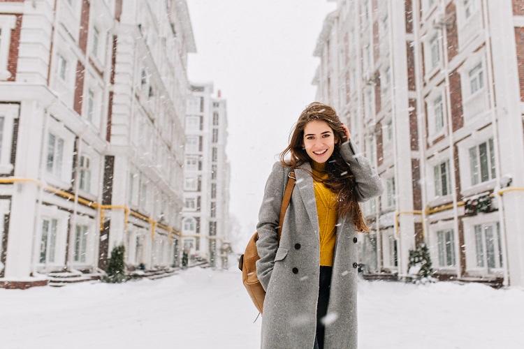 charming-young-woman-in-coat-with-long-brunette-hair-enjoying-snowfall-in-big-city-cheerful-emotions-smiling-christmas-mood-positive-face-emotions-winter-weather-place-for-text.jpg