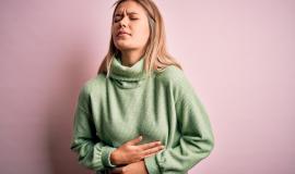 young-beautiful-blonde-woman-wearing-winter-wool-sweater-pink-isolated-background-with-hand-stomach-because-nausea-painful-disease-feeling-unwell-ache-concept_839833-7960.jpg