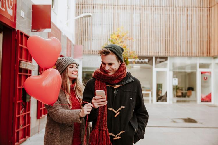 couple-with-balloons-and-smartphone_23-2147736011.jpg